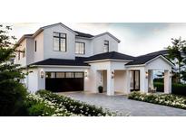 Two-story white house with black roof and windows, and landscaping at 3304 Harrison Ave, Orlando, FL 32804