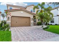 Two-story house with a brown garage door and stone accents at 8150 Prestbury Dr, Orlando, FL 32832