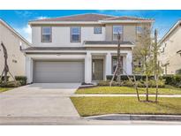 Two-story house with gray siding and a two car garage at 438 Marcello Blvd, Kissimmee, FL 34746