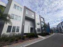 Modern, two-story townhome with light gray and white siding at 7740 Sandy Ridge Dr # 213, Reunion, FL 34747