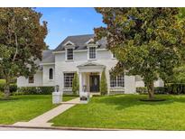 Two story house with white brick exterior, manicured lawn, and walkway at 2234 Via Luna, Winter Park, FL 32789