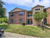 Brick and siding two-story building with landscaping and parking at 5545 Devonbriar Way # I101, Orlando, FL 32822