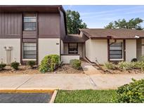 Two-story condo building with brown siding and paved walkway at 225 Terrace Hill Blvd # 1C, Debary, FL 32713