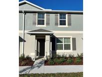 Two-story townhome with gray siding, dark shutters, and landscaping at 2849 Rotterdam Dr, Apopka, FL 32703