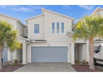 Modern house exterior with gray garage door and landscaping at 3387 Beaute Dr, Kissimmee, FL 34746