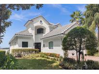 Two-story house with white exterior, grey roof and landscaping at 8629 Saint Marino Blvd, Orlando, FL 32836