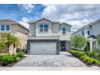 Two-story house with stone accents and a paved driveway at 171 Burma St, Kissimmee, FL 34747