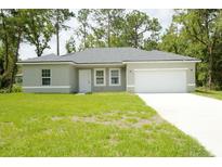 Single-story house with a two-car garage and well-maintained lawn at 6952 Sw 152Nd St, Ocala, FL 34473