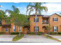 Townhouse with orange exterior and lush landscaping at 244 Capri Dr, Davenport, FL 33897