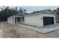 Newly constructed home with a modern design and attached garage at 2211 Simmons Ave, Leesburg, FL 34748