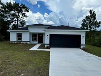 Modern house exterior with a white and black color scheme and a two-car garage at 15096 Sw 51St Ave, Ocala, FL 34473