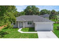 Single-story home with attached garage and landscaped lawn at 370 Routh Ave, New Smyrna Beach, FL 32168