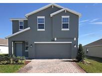 Two-story home with gray siding, two-car garage, and landscaped yard at 2854 Black Birch Dr, Ocoee, FL 34761