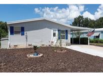 Exterior view of a manufactured home with landscaped yard and American flag at 550 Saint Johns Rd, Tavares, FL 32778