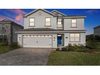 Two-story home with a three-car garage and landscaped yard at 8903 Stinger Dr, Davenport, FL 33896