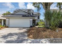 Gray two-story house with a white garage door and landscaping at 551 Cidermill Pl, Lake Mary, FL 32746