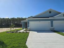 Exterior view of a light blue two-car garage home with landscaping at 2608 Kinsale Ln, Ormond Beach, FL 32174