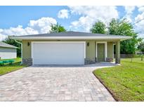 New construction home with a green exterior, white garage door, and paved driveway at 2261 Greenway St, Sanford, FL 32771