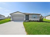 One-story home with gray siding, light-colored trim, and a two-car garage at 1717 Forest Run Ln, Auburndale, FL 33823