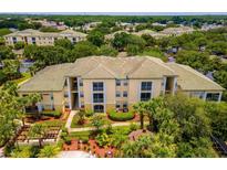 Exterior view of a two-story condo building with palm trees and landscaping at 8810 Dunes Ct # 203, Kissimmee, FL 34747