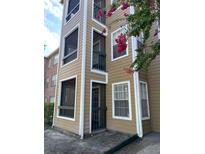 Tan 3-story building with balconies and lush landscaping at 4301 Lizshire Ln # C-109, Orlando, FL 32822