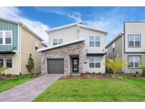 Modern two-story home with stone and gray siding at 2771 Oxymoron Way, Kissimmee, FL 34746