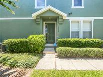 Green two-story townhome with a private entrance and well-manicured landscaping at 10888 Eclipse Lily Way # 62A, Orlando, FL 32832