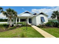 Charming white house with blue shutters at 1077 Sugar Loaf Key Loop, Lady Lake, FL 32159