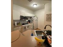 Well-equipped kitchen with white cabinets and modern appliances at 5518 Metrowest Blvd # 207, Orlando, FL 32811