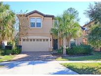 Two-story house with attached garage and palm trees at 8887 Qin Loop, Kissimmee, FL 34747