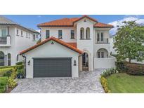 Two-story home with a gray garage door and red tile roof at 610 Muirfield Loop, Reunion, FL 34747