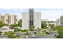 Aerial view of waterfront condo building with parking and pool at 6165 Carrier Dr # 1214, Orlando, FL 32819