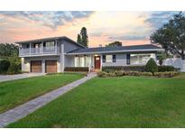 Two-story home with gray brick, updated garage doors, and a paved walkway at 515 N Boyd St, Winter Garden, FL 34787