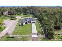Stunning aerial view of a modern farmhouse with fenced yard at 3429 Boggy Creek Rd, Kissimmee, FL 34744