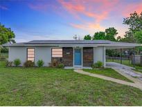 Charming ranch home with solar panels, blue door, and landscaped lawn at 1567 Fort Smith Blvd, Deltona, FL 32725