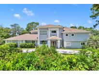 Two-story house with a circular driveway and lush landscaping at 9 Stone Gate N, Longwood, FL 32779