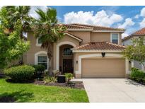 Two-story house with tan exterior, brown roof, and a two-car garage at 5237 Oakbourne Ave, Davenport, FL 33837