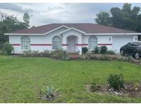 Single story home with red roof and well maintained lawn at 2135 Sw 156Th Pl, Ocala, FL 34473