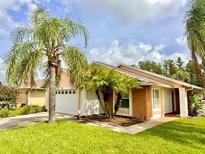 One-story home with palm trees and a landscaped lawn at 5135 Warrior Ln, Kissimmee, FL 34746