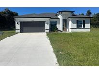 Modern home with gray garage door and green lawn at 14954 Sw 38Th Cir, Ocala, FL 34473