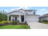 Two-story house with a front porch, driveway, and landscaping at 1105 Pacific Dunes Ct, Daytona Beach, FL 32124
