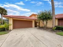 Front view of a tan house with a brown garage door at 4934 Samoa Cir # 7, Orlando, FL 32808