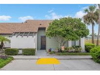 Single-story condo with a light green exterior, and a well-maintained front yard at 2384 Sun Valley Cir, Winter Park, FL 32792