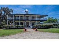 Two-story house with wrap-around porch and manicured lawn at 16600 Cleveland Ln, Umatilla, FL 32784
