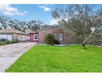 Brick house with red accents, a grassy lawn and driveway at 501 N Normandale Ave, Orlando, FL 32835