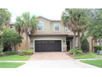 Two-story house with dark brown garage door and palm trees at 9054 Rhodes St, Kissimmee, FL 34747
