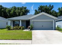 Gray house with two-car garage and well-manicured lawn at 3882 Willow Ridge Dr, Lakeland, FL 33810