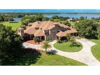 Luxury home with lake view and circular driveway at 9400 Laws Rd, Clermont, FL 34714