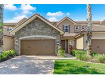 Two story home with stone accents and brown double doors garage at 10747 Belfry Cir, Orlando, FL 32832