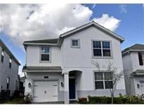 Two-story home with light gray exterior and a two-car garage at 1585 Mulligan Blvd, Davenport, FL 33896